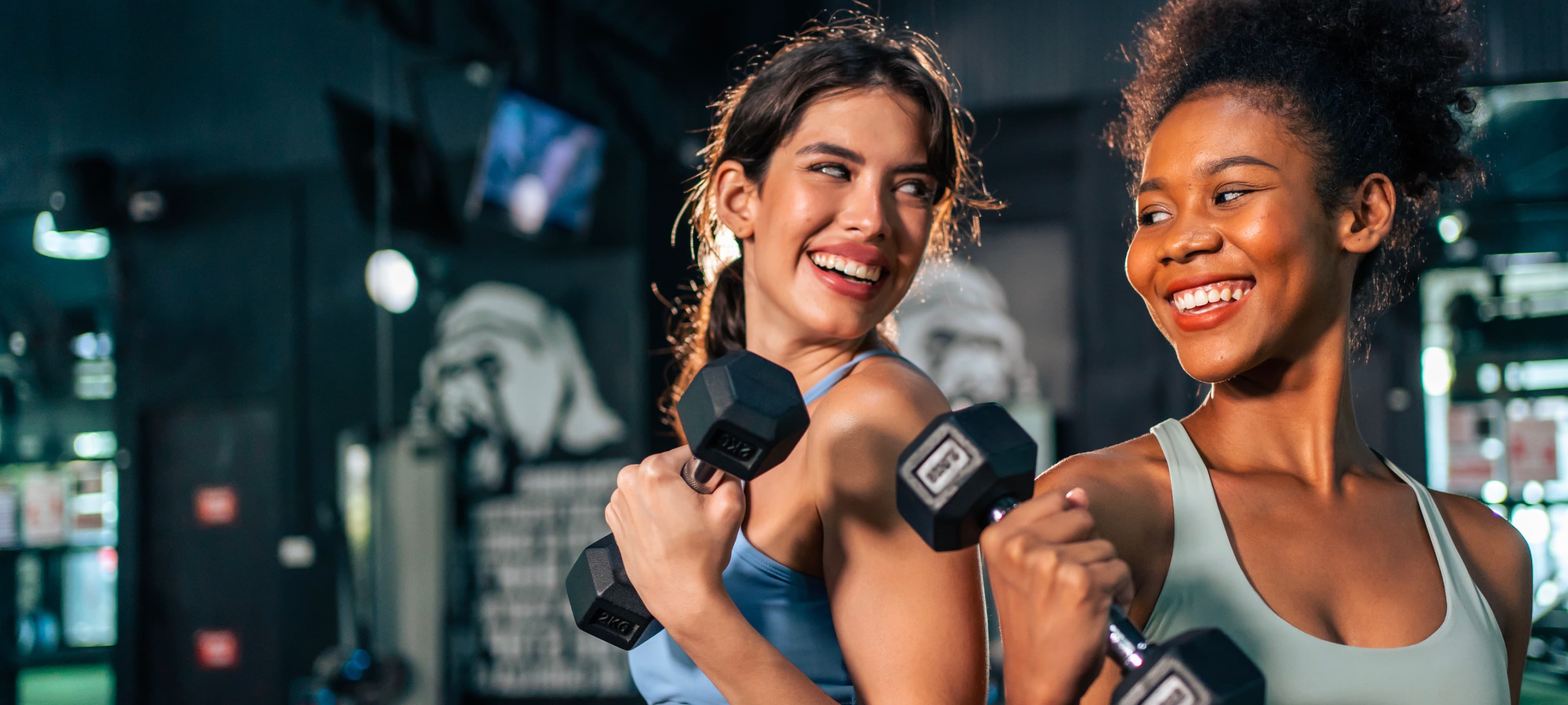 Mulheres treinando com halteres em uma academia